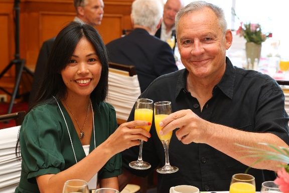 two Dal alumni clink glasses at an event